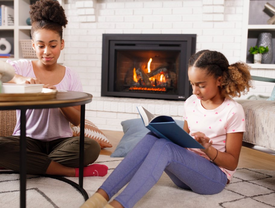 Girls reading next to fireplace