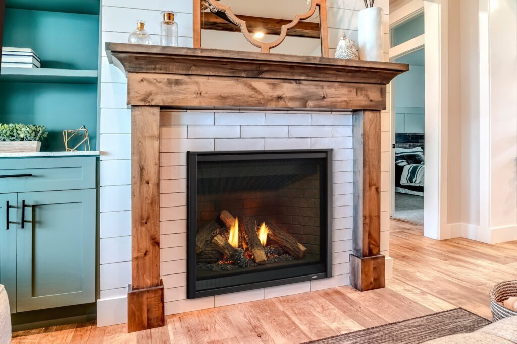 Modern fireplace with wooden frame against white wall inside living area of home. Built in display shelf cabinet and polished wooden floor can also be seen inside the room.