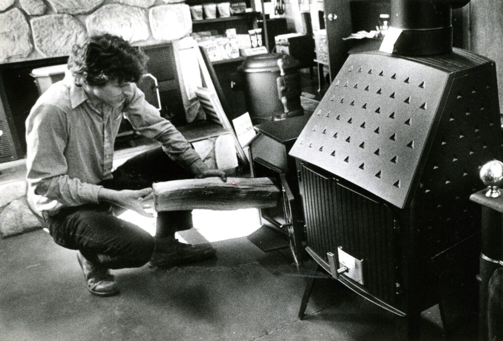 Bill Ryan filling a stove with wood