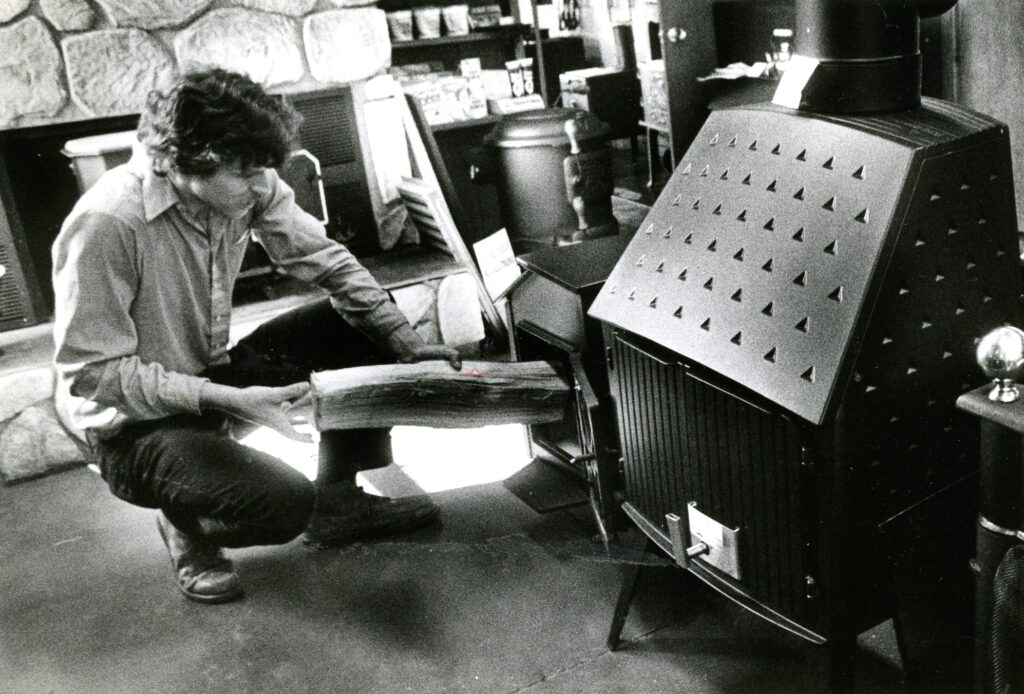 Bill, owner of The Stove Shop, filling a wood stove.