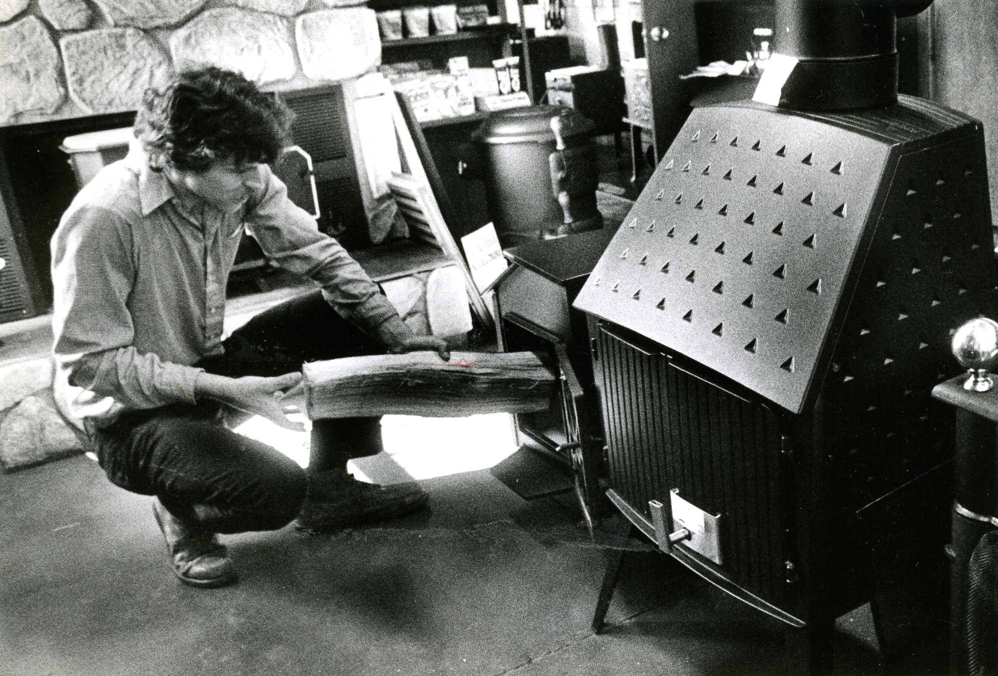 Bill, owner of The Stove Shop, filling a wood stove.