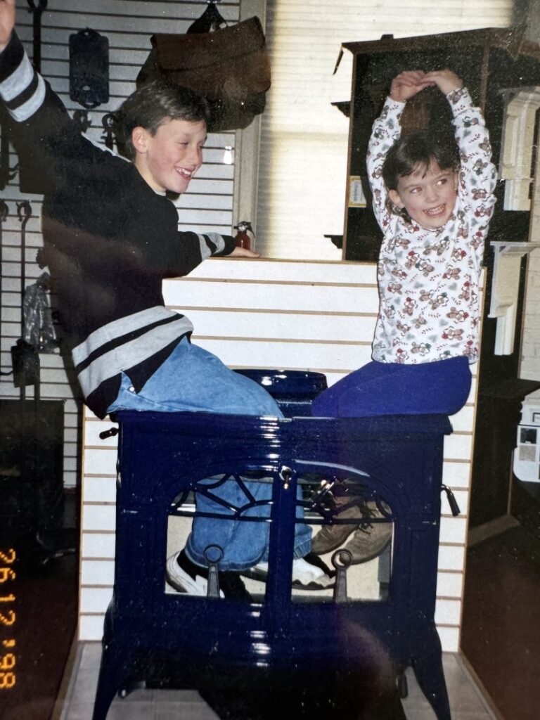Kids sitting in a wood stove