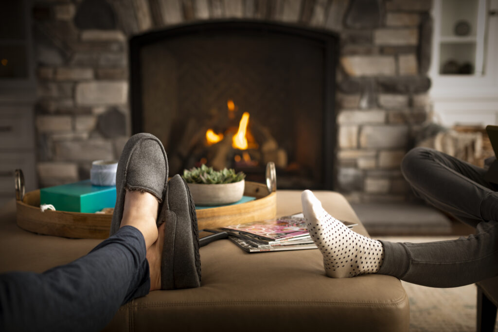 People relaxing next to fireplace