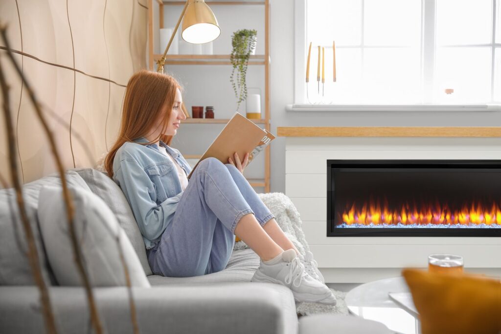 Girl studying next to linear electric fireplace