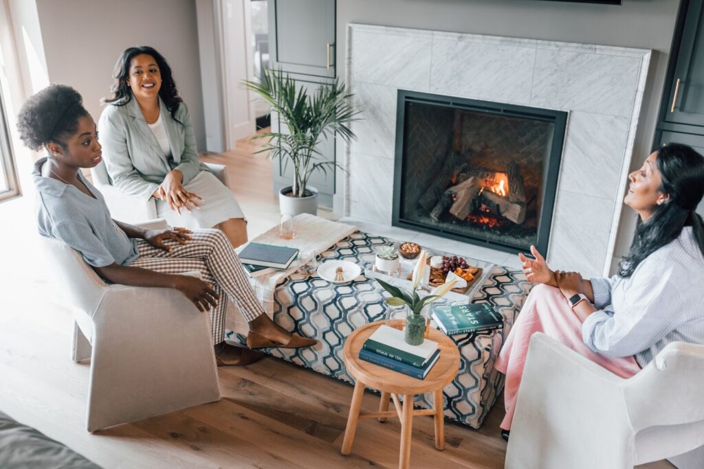 Women sitting around a gas fireplace