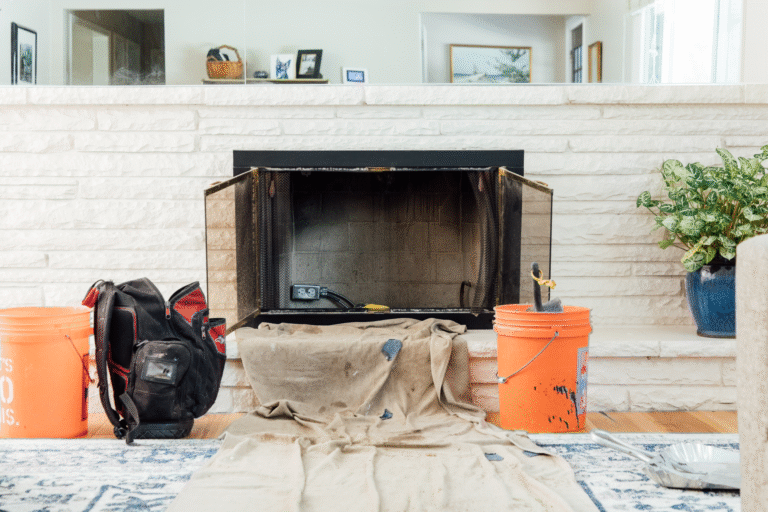 fireplace open dirty ready to be cleaned with tools nearby