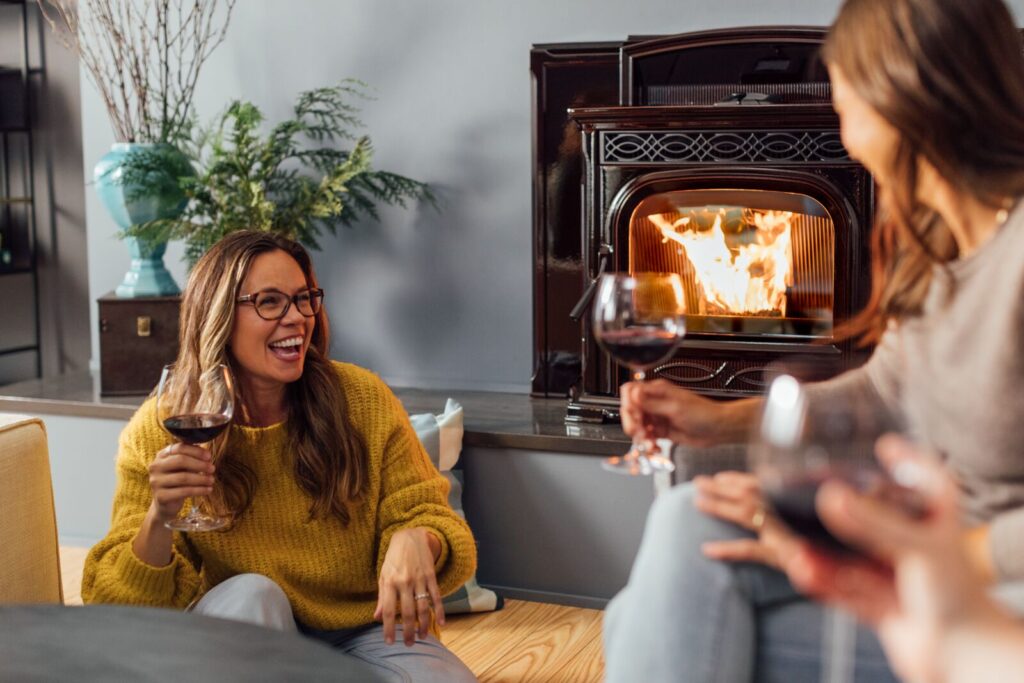 accentra pellet fireplace insert from harman being enjoyed by a group of friends with wine, cheese and laughs